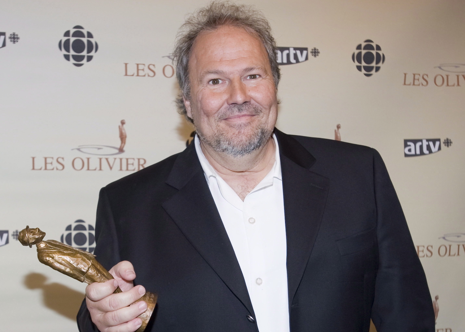 Jean-Marc Parent holds up his award for best comedy show 'Torture' at the Olivier awards gala in Montreal, Sunday, May 13, 2012. THE CANADIAN PRESS/Graham Hughes