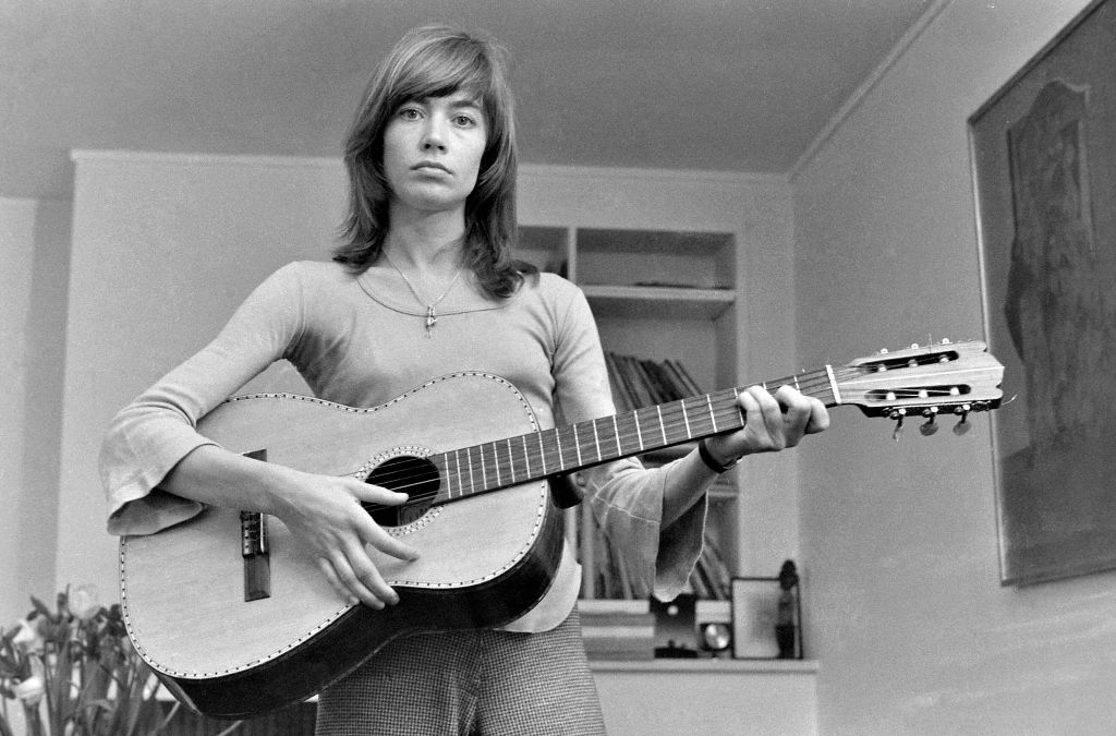 French singer, songwriter and actress Francoise Hardy holds a acoustic guitar as she poses at her apartment in Paris, September 1973. (Photo by Wojtek Laski/Getty Images)