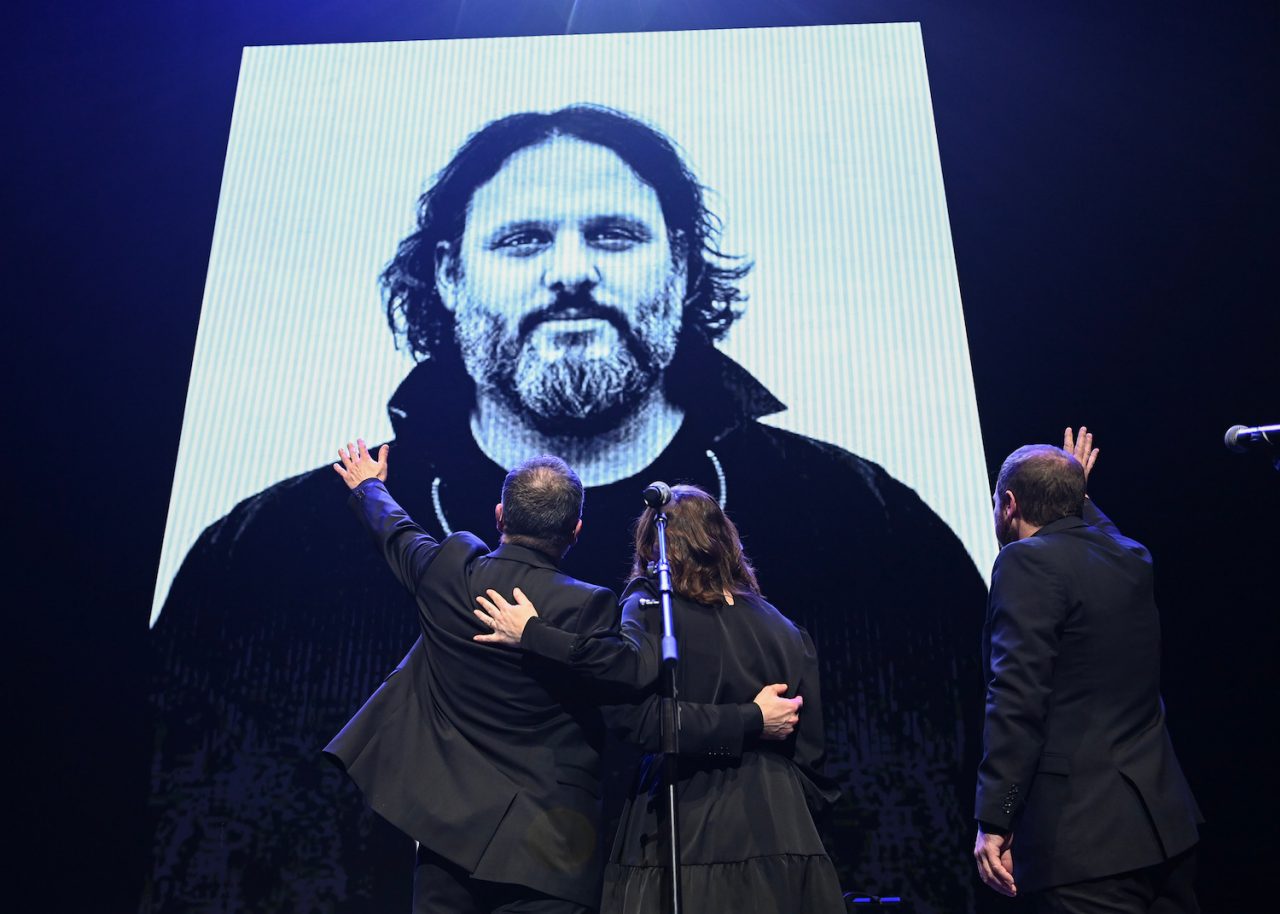 Members of Les Cowboys Fringants wave to a photograph  during an event paying tribute to the late Karl Tremblay, lead singer of the ban, in Montreal, Tuesday, November 28, 2023. THE CANADIAN PRESS/Graham Hughes