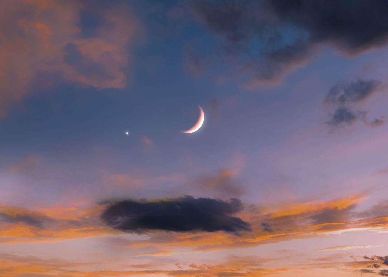 New moon in the sky near Venus at sunset. Venus next to the Moon. Beautiful celestial landscape.