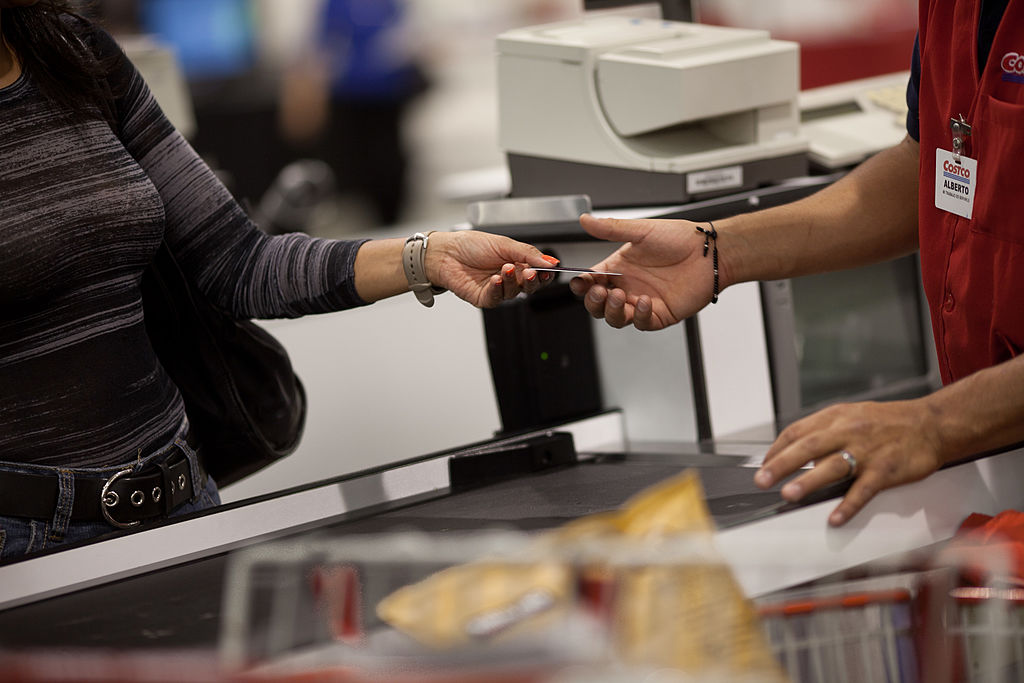 HUIXQUILUCAN, MEXICO - MAY 21: Mayra Guitierrez hands the cashier her membership card to make purchases at the Costco in Huixquilucan, Estado de Mexico outside of Mexico City. Mayra said the family comes to make purchases nearly every 15 days to buy in bulk and save money. (Photo by Dominic Bracco II for The Washington Post via Getty Images)