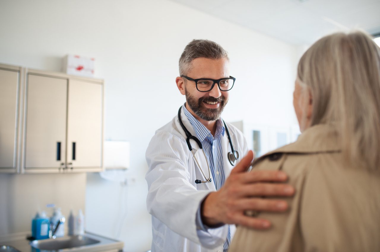 Young doctor greetings  elderly woman patient.