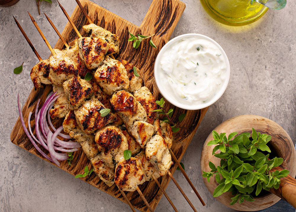 Greek chicken souvlaki with tzatziki sauce and fresh vegetables, grilled kebabs