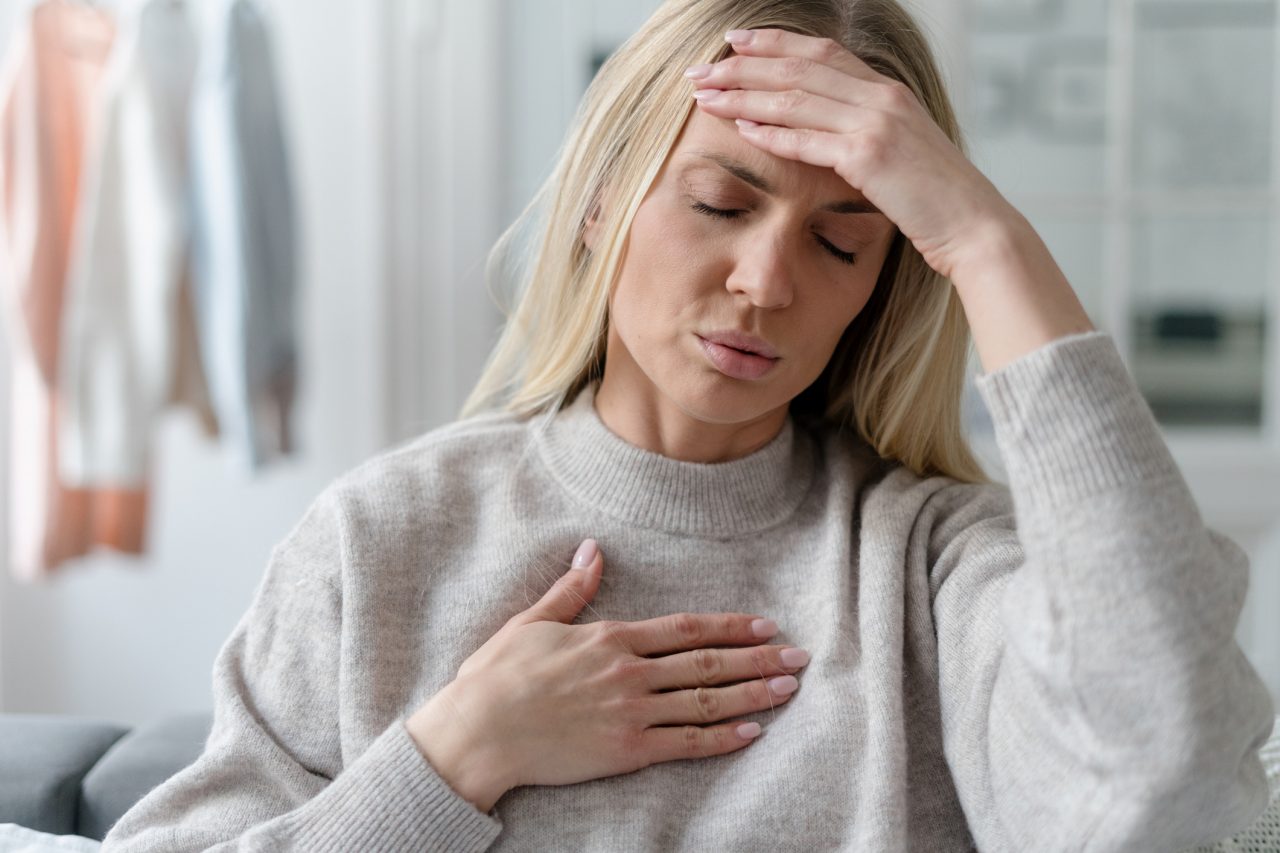 blonde young female in sweater feel fatigue, asthma attack or dyspnea at home. illness girl with headache and cardiac pain