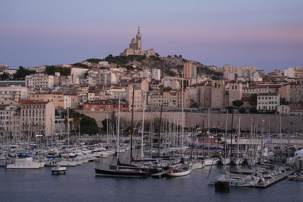 The Notre Dame de la Garde Basilica is seen on a top of the hill during a sunset in Marseille, France, Tuesday, Sept. 19, 2023. (AP Photo/Pavel Golovkin)